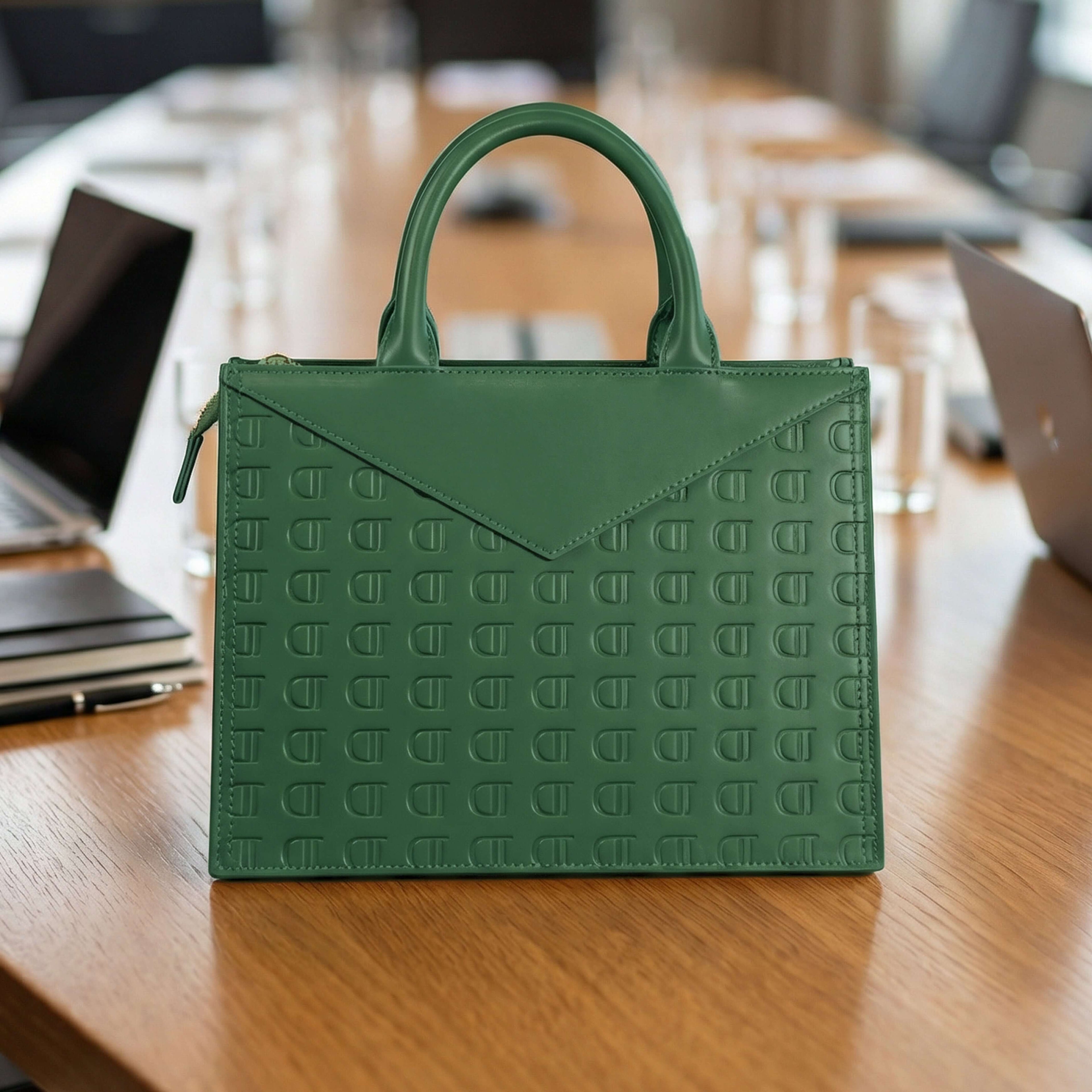 Luxury Green Leather Envelope Bag resting on a wooden table displaying its structured design